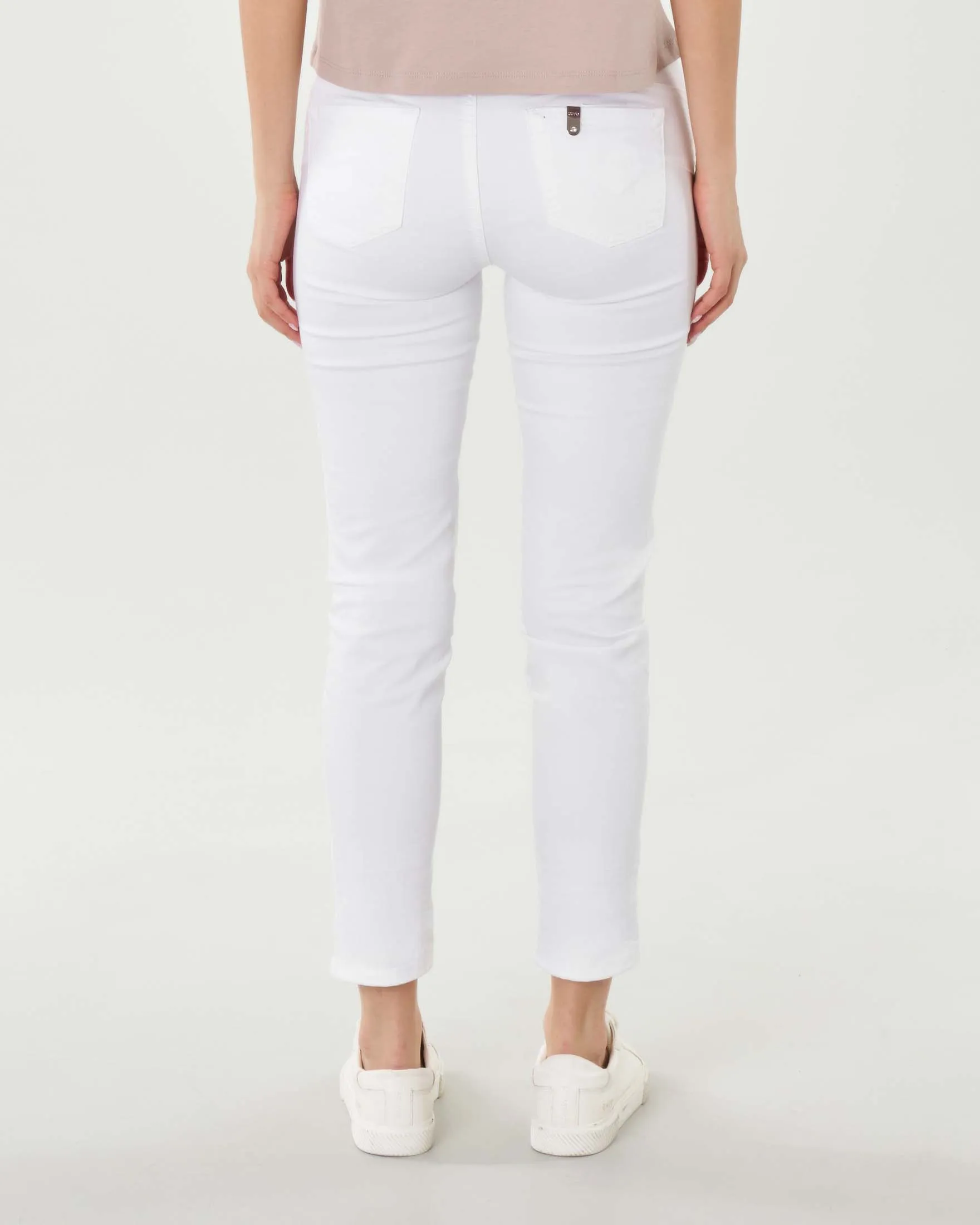 White slim ankle-length stretch cotton pants with visible button closure.